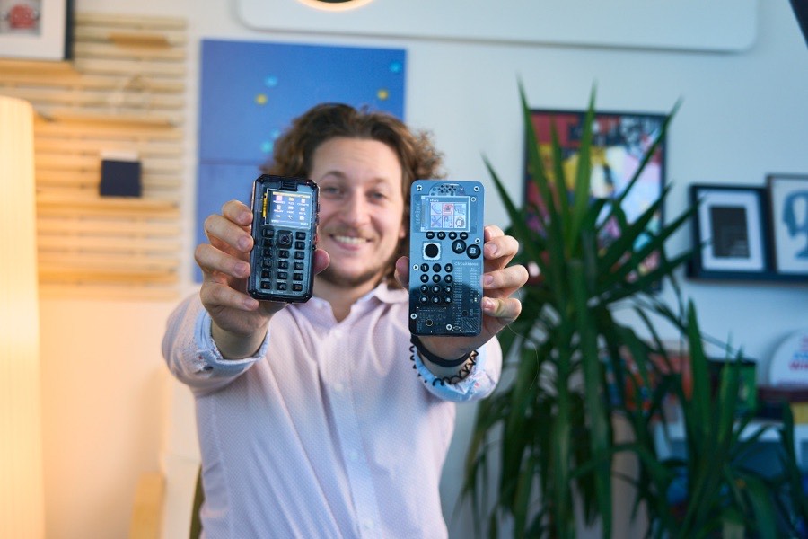 Albert Gajšak holding out two MAKERphone units side by side at arm's length.